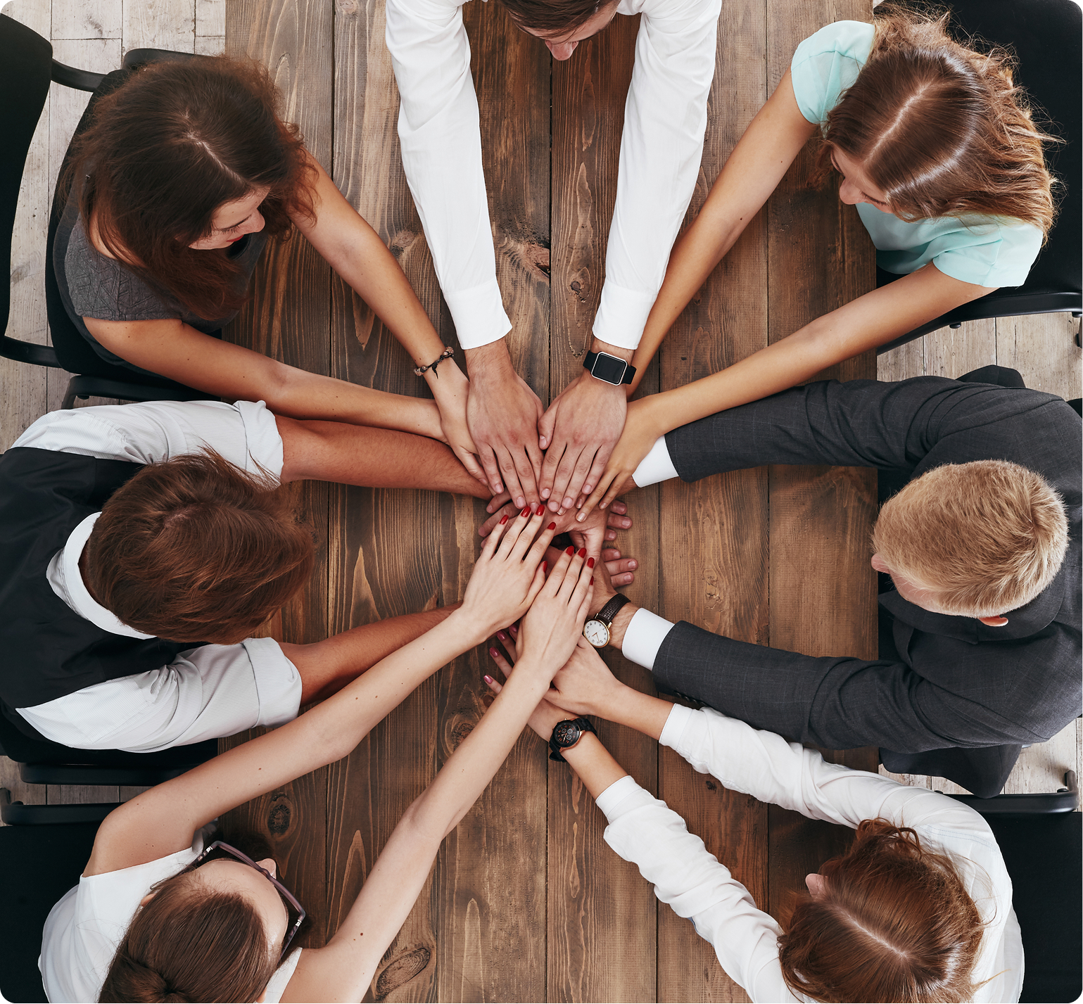 Two professionals in business attire shaking hands over a conference table to confirm a corporate funding agreement.